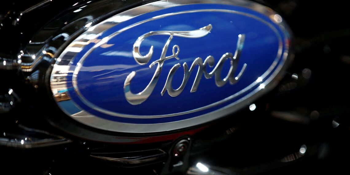 Logotipo da Ford em destaque, com fundo azul e bordas cromadas, representando a marca automobilística.