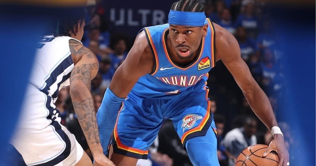 Jogador de basquete em ação, driblando adversário durante partida do Oklahoma City Thunder. Foco no dinamismo do jogo.