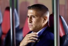 Imagem de Hernán Crespo comemorando com os jogadores do Vasco em um estádio lotado após uma vitória emocionante que garantiu a qualificação do time para uma fase decisiva do campeonato.