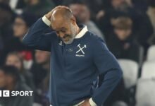 Nuno Espirito Santo looks downwards with his right hand clasped to the top of his head during West Ham
