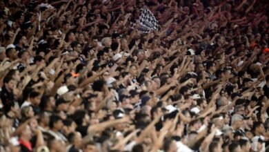 Torcida organizada do Corinthians celebra retorno aos estádios após liberação judicial, destacando bandeiras e entusiasmo dos torcedores.