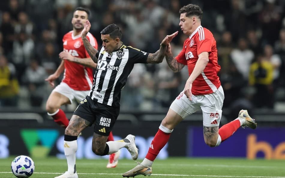 Jogo entre Atlético-MG e Internacional no Brasileirão em busca de estabilidade, com jogadores em ação em um campo de futebol.