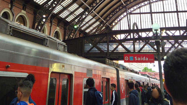 Passageiros utilizando o metrô de São Paulo com pagamento de passagens por aproximação de cartão, destacando a inovação tecnológica no transporte público.