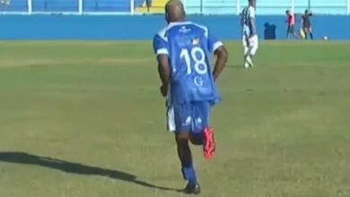Jogador do Goytacaz em campo usando tornozeleira eletrônica, destaca-se em meio à repercussão internacional sobre sua participação em partidas de futebol.