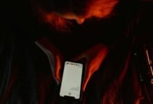 Pessoa relaxando em um parque ensolarado, lendo um livro, representando estratégias eficazes para combater a exaustão mental e reduzir o uso de redes sociais.